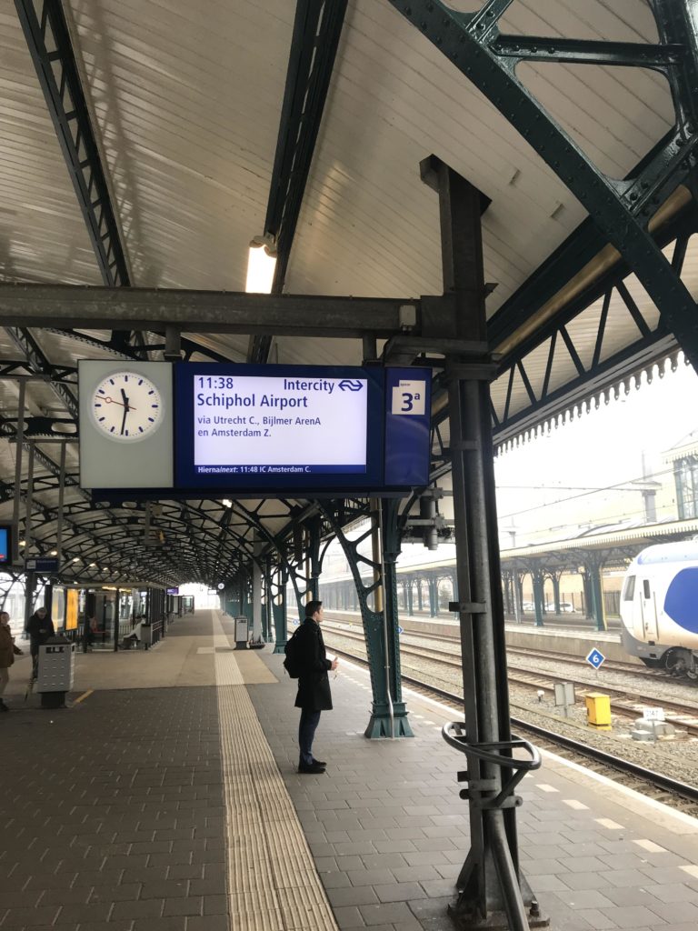 Picture of a man waiting for a train to Schiphol Airport on a platform at the train station in Den Bosch, The Netherlands